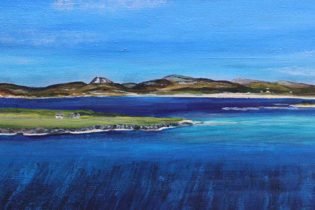 Coastal landscape with blue water and green land, featuring a small island.