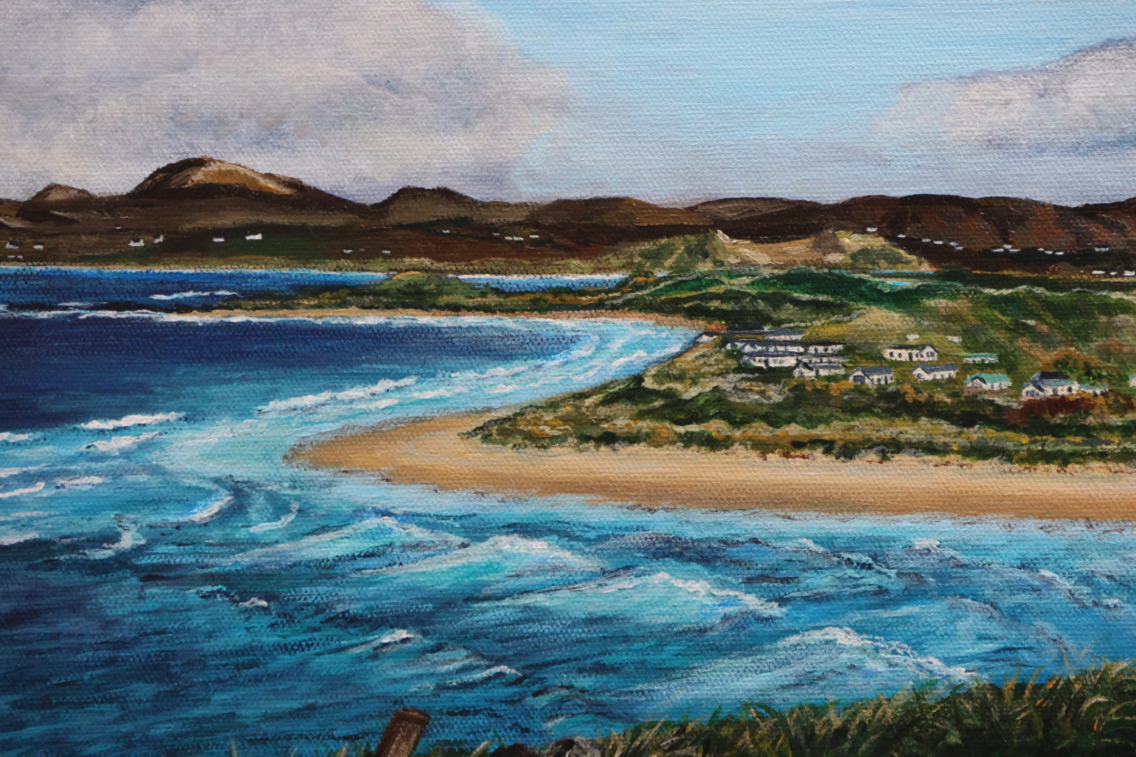 Painting of a coastal landscape with blue water, sandy beach, and green hills.